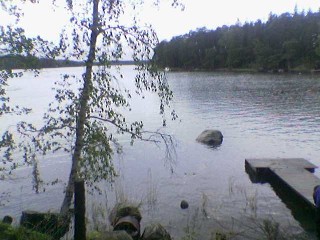 Kuvassa kes�inen rantamaisema laitureineen ja koivuineen